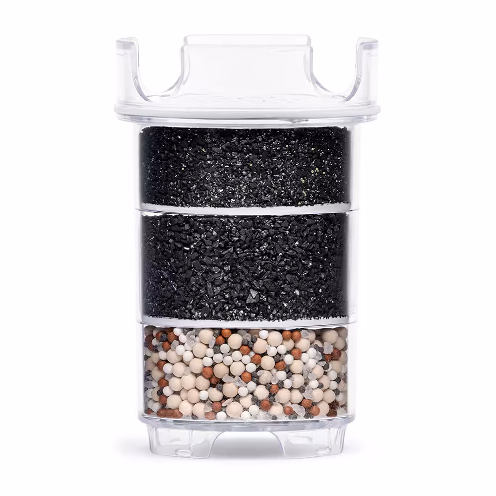 Cross-section of a Lotus Vita ENYA water filter cartridge, revealing its multi-layer system of activated carbon and mineral stones for water purification.