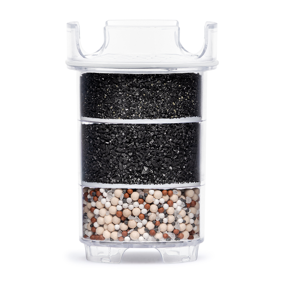 Cross-section of a Lotus Vita ENYA water filter cartridge, revealing its multi-layer system of activated carbon and mineral stones for water purification.
